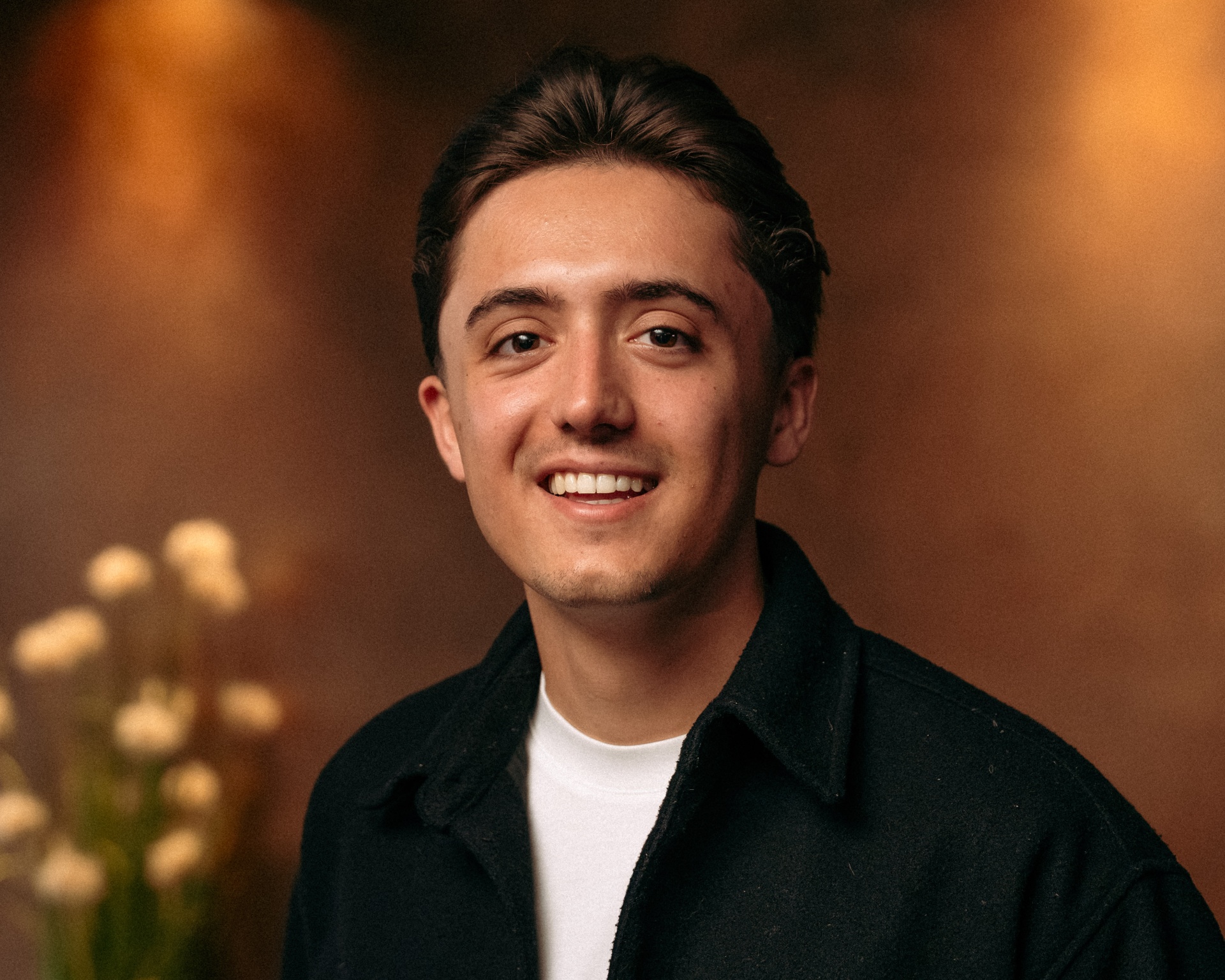 Portret van Sem Egberts, glimlachend in een warm verlichte ruimte